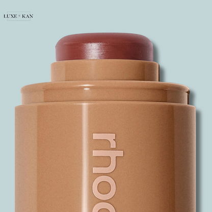 Close-up of a rhodod blush stick in a warm brown shade, showcasing the smooth top and sleek packaging.