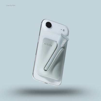 A grey Rhode Snap-On Lip Balm Holder for Iphone 17 with a pale blue Peptide Lip Treatment tube secured on the back.