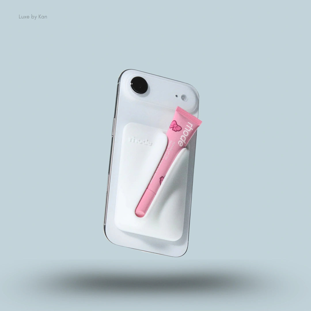 A white Rhode Snap-On Lip Case for Iphone 17 with a pink Peptide Lip Treatment tube secured on the back.