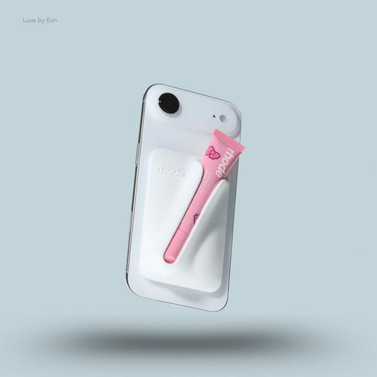 A white Rhode Snap-On Lip Case for Iphone 17 with a pink Peptide Lip Treatment tube secured on the back.