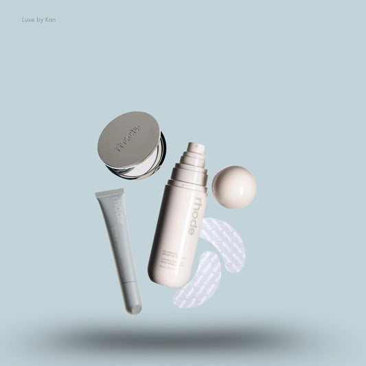 Rhode On-The-Go Set includes a lip treatment tube, glazing milk, peptide lip treatment, and eye masks on a light blue backdrop.