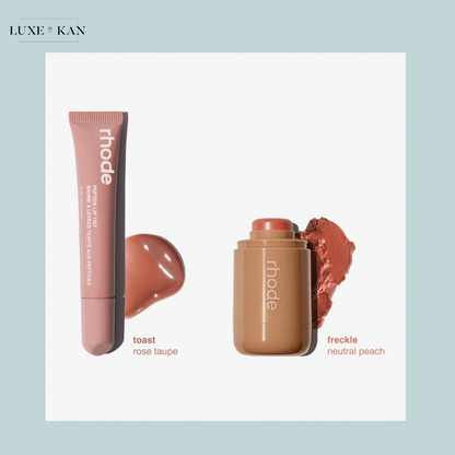Two makeup products from Rhode: a rose taupe lip tint labeled "toast" and a neutral peach cheek tint labeled "freckle" beside them.
