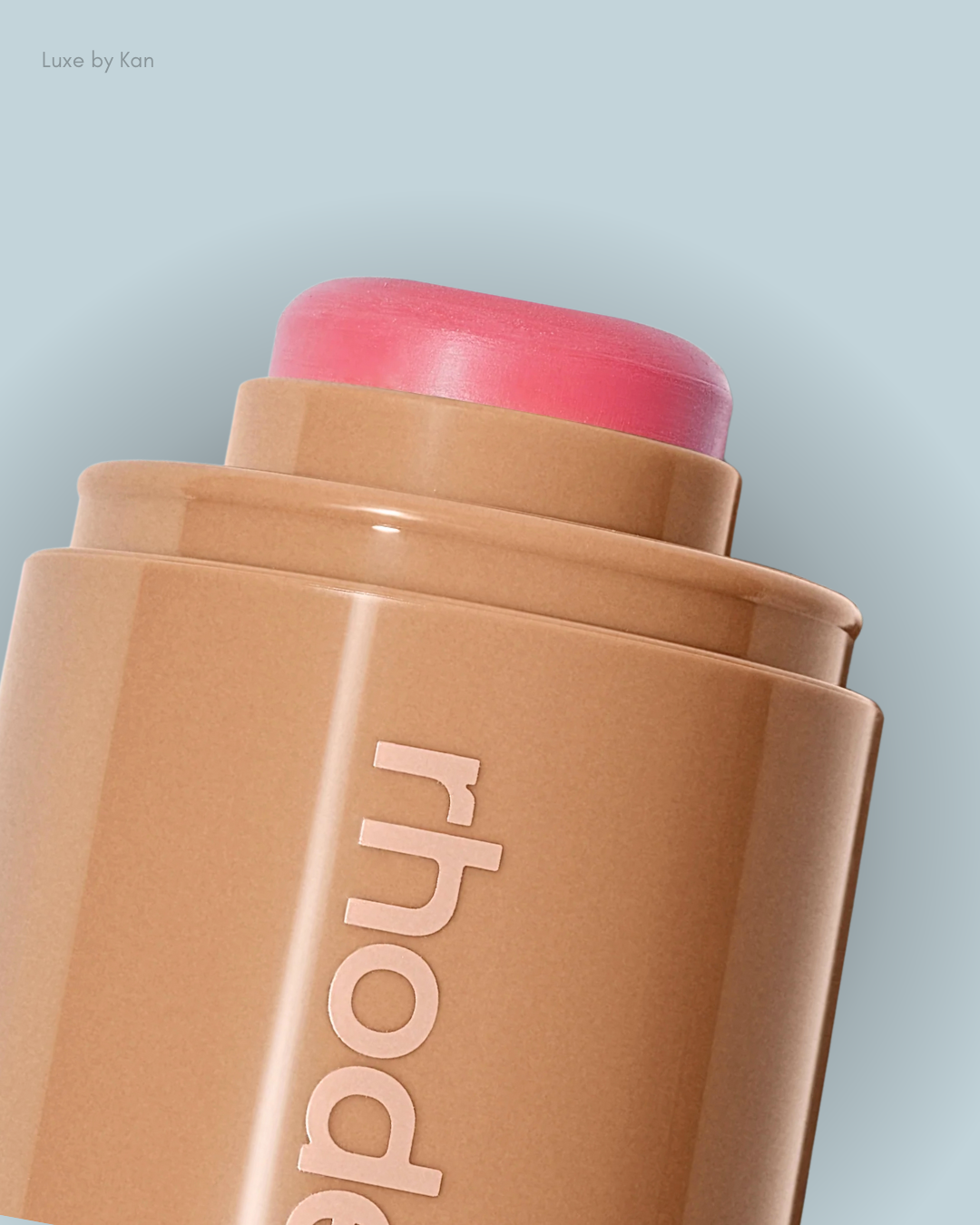 Close-up of a pocket blush with a soft pink top, featuring the brand name "rhode" on the container.