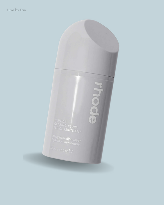 A sleek gray bottle of rhode Peptide Glazing Fluid, highlighting its hydrating properties.