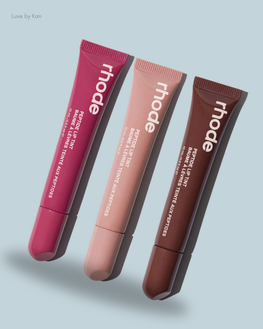 Three tubes of rhode Peptide Lip Tint in shades of berry, nude, and brown.