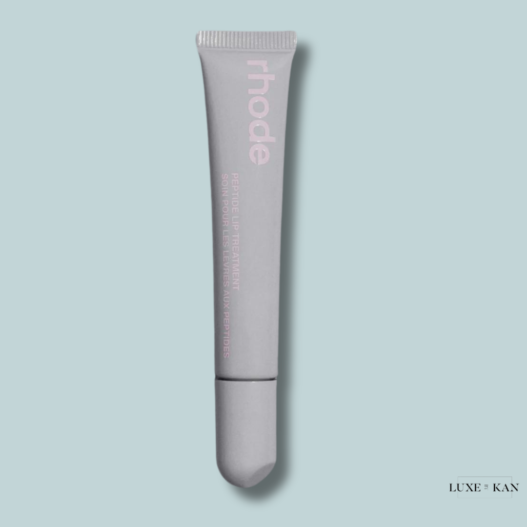 A gray tube labeled "rhode Peptide Lip Treatment" against a light blue background, designed for enhancing lip moisture.