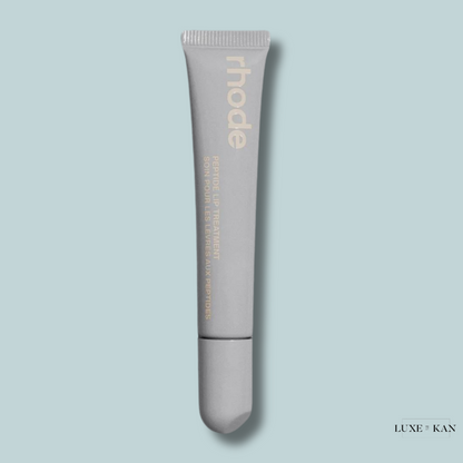A gray tube of rhode Peptide Lip Treatment against a light blue background, labeled in elegant gold text.