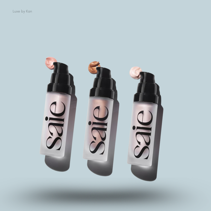 Three Saie Glowy Super Gel bottles with different shades on their respective black pumps on a blue background.