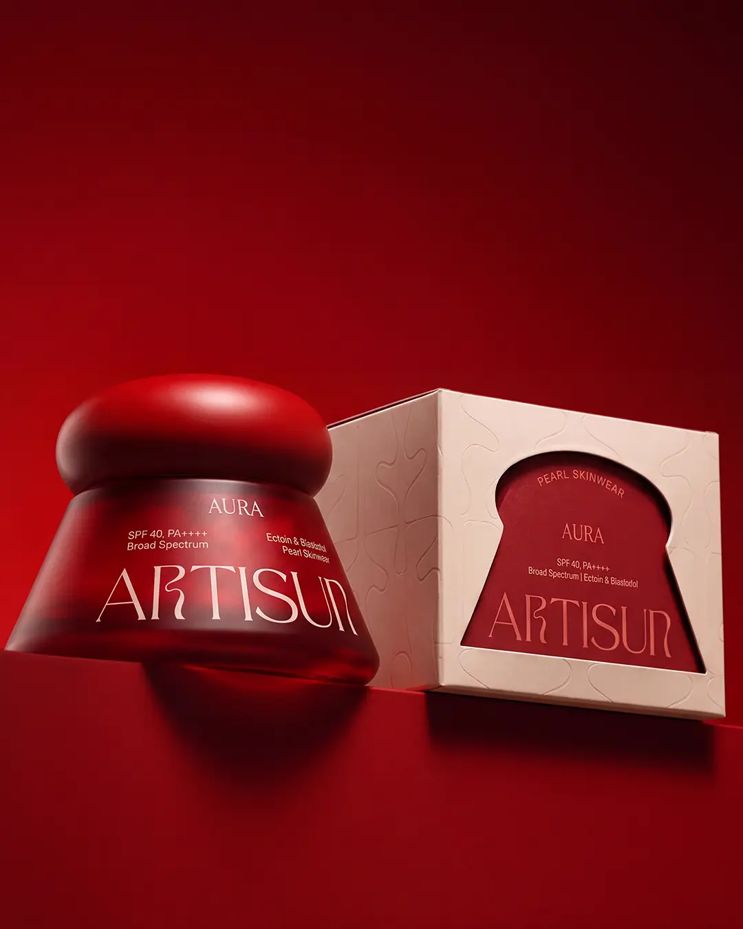 artisun Aura Pearl Skinwear Sunscreen SPF 40 PA++++ product with packaging on a clean maroon background