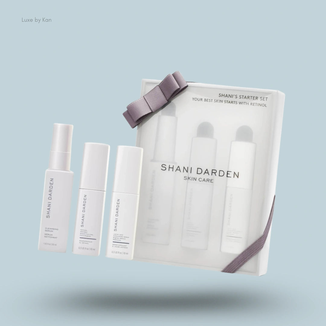 Three Shani Darden skincare bottles beside a Shani’s Starter Kit box tied with a gray ribbon.