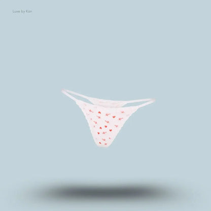 SKIMS Lightweight Cotton Pointelle Lace String Thong in Snow Arrowed Hearts, flat lay on light blue background