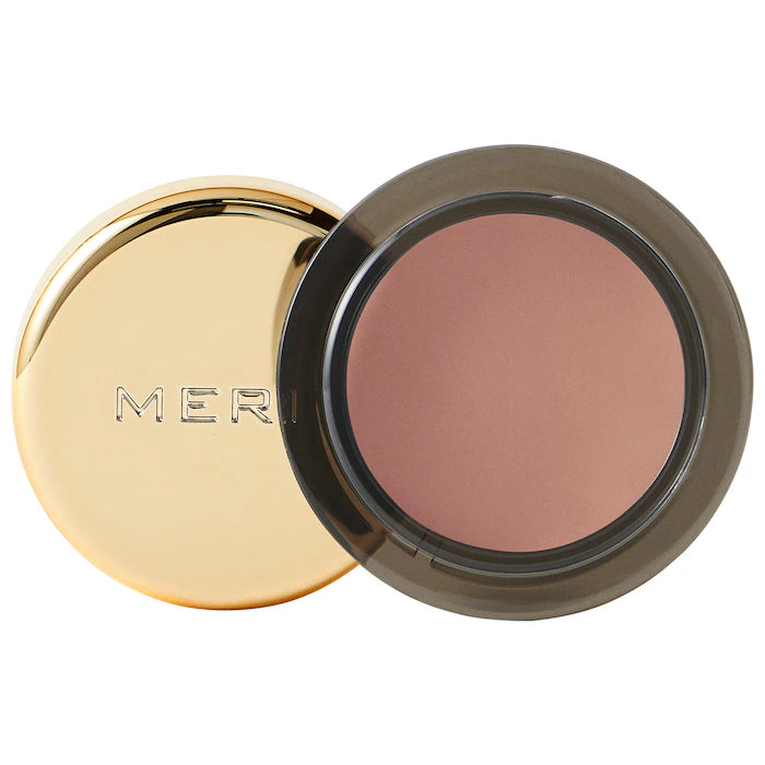 Close-up of a round, gold compact from Merit beauty's solo shadow cream-to-powder soft matte eyeshadow, revealing a soft, muted rose blush shade inside.
