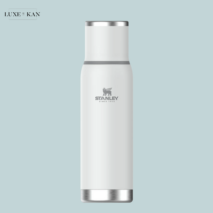 A sleek, white stainless steel 'Adventure To-Go' water bottle by Stanley, featuring a silver logo and modern design.