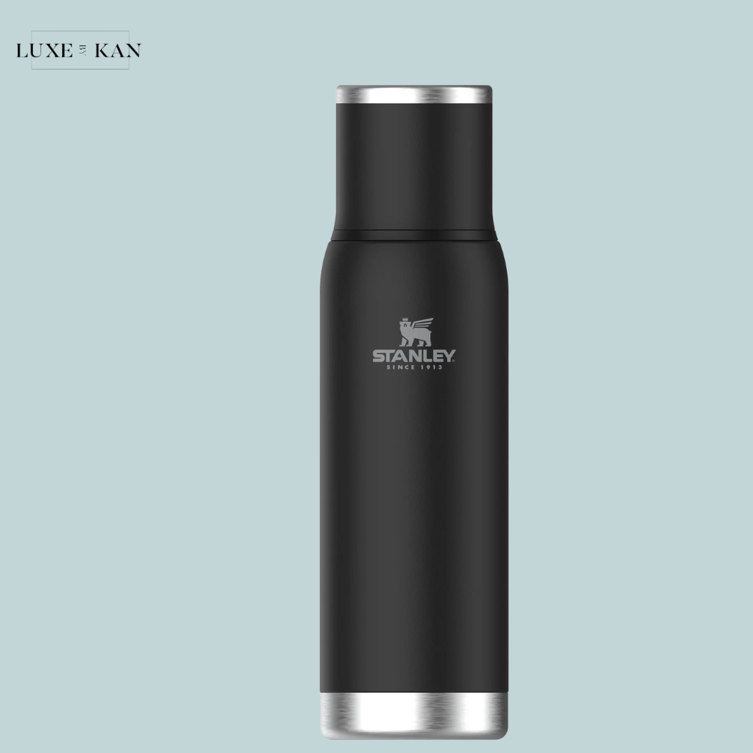 Black stainless steel Stanley insulated water bottle with silver accents, featuring the Stanley logo and a sleek, modern design.