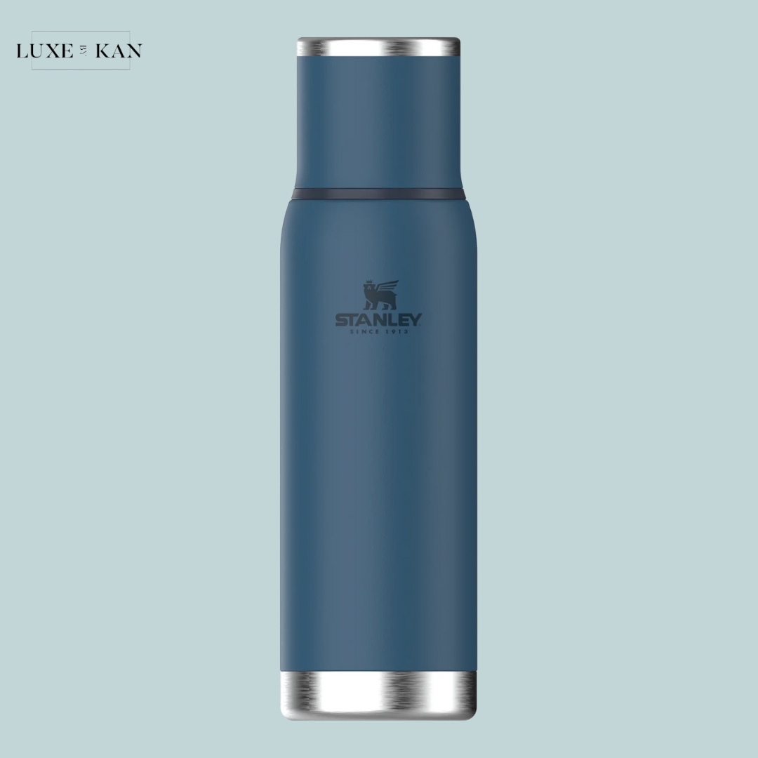 A sleek, blue stainless steel water bottle with a silver base and the Stanley logo.