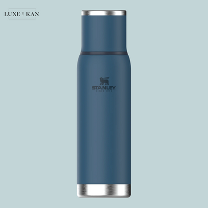 A sleek, blue stainless steel water bottle with a silver base and the Stanley logo.