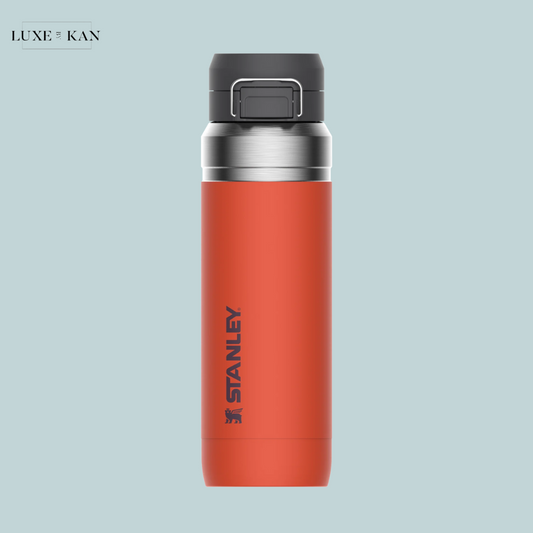 A vibrant orange Stanley go quick flip water bottle with a stainless steel lid.