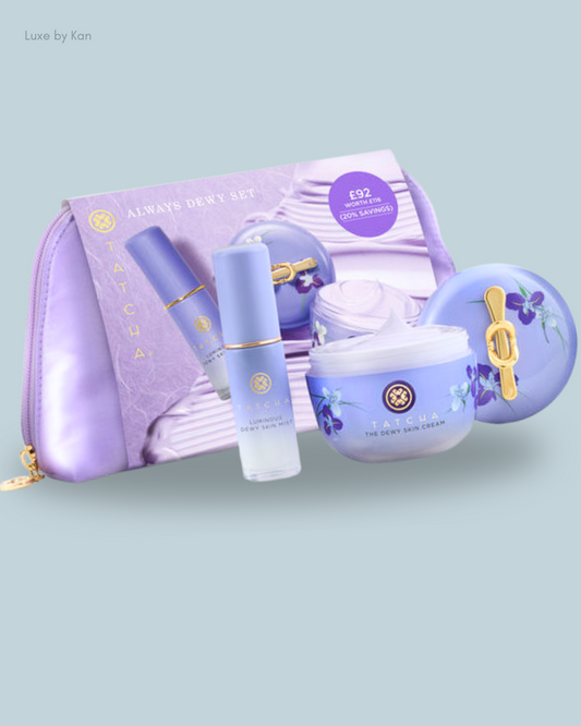A Tatcha Always Dewy Set featuring a lilac cosmetic bag, cream, and mist, showcasing elegant packaging.