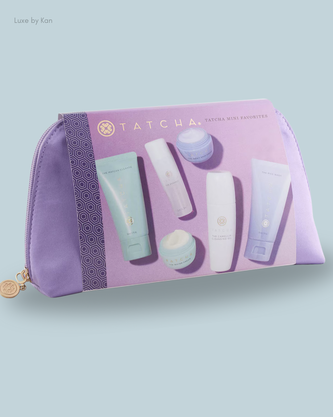 A lavender pouch displaying Tatcha's Mini Favorites Skincare Set, including cleansers and creams.