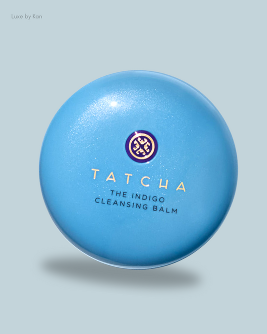 A round, blue container of Tatcha's Indigo Cleansing Balm featuring elegant gold lettering and a logo.