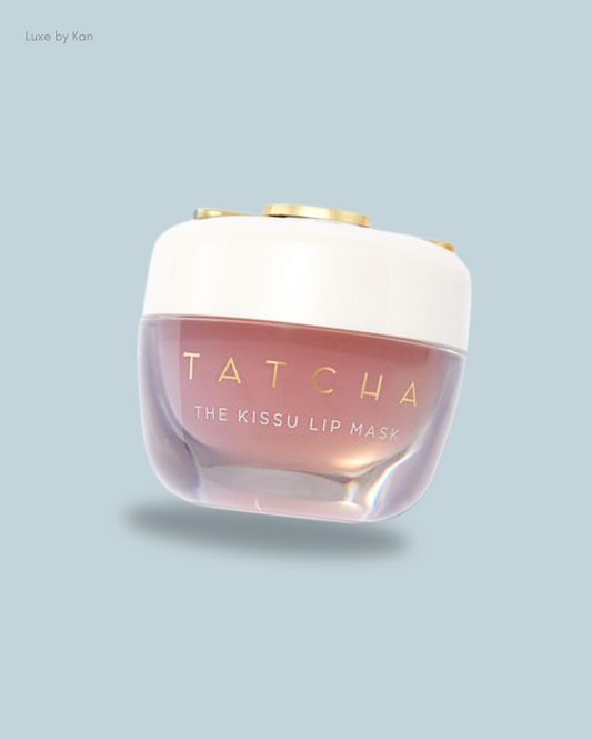 A Tatcha Kissu lip mask jar with a gold lid, featuring a soft pink lip balm inside.