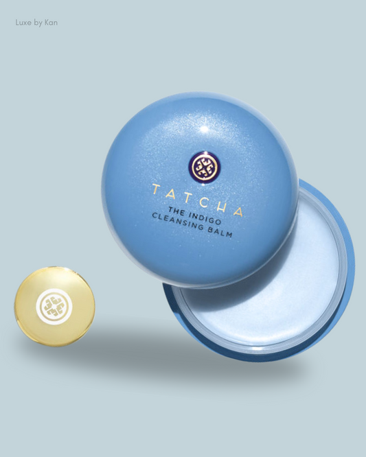 Close-up of Tatcha's Indigo Cleansing Balm, featuring a round blue jar with a gold cap, showcasing its creamy texture inside.