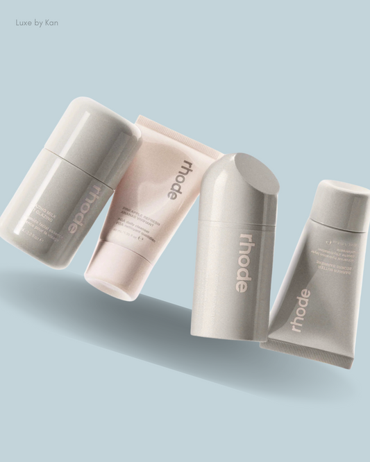 Four travel skincare set products from rhode, featuring sleek gray and pink packaging.