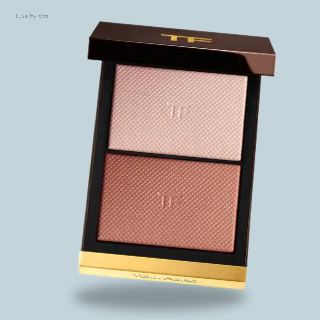 A Tom Ford two-toned blush palette featuring light pink and warm peach shades, elegantly housed in a sleek black and gold case.