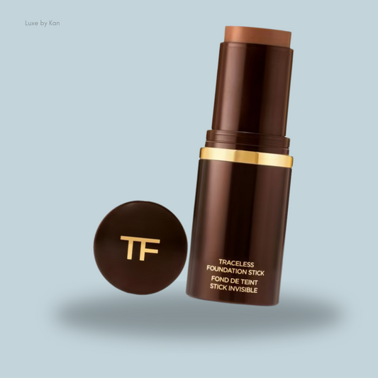Tom Ford Traceless Foundation Stick in a sleek brown tube, displayed upright with cap beside it.