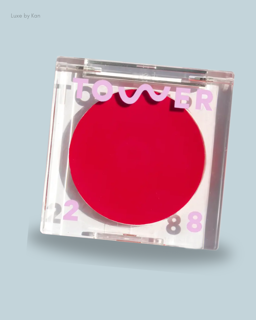 Close-up of a BeachPlease Luminous Tinted Balm featuring a vibrant red blush, labeled "TOWER 28" in playful pink lettering.