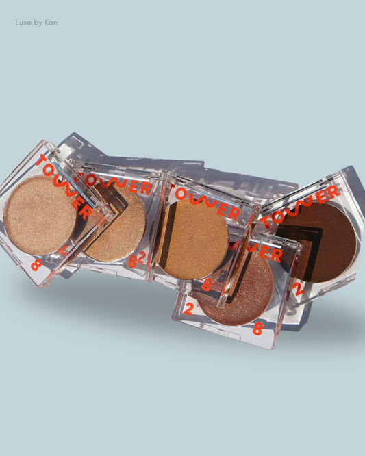 A collection of Bronzino Illuminating Cream Bronzers in various shades, each featuring the brand name "Tower 28."
