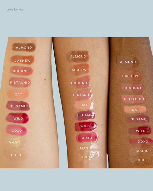 Swatches of various lip colors on two arms showcasing shades: Almond, Cashew, Coconut, Pistachio, Oat, Sesame, Wild, XOXO, Magic, Chill.