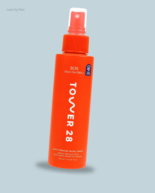 A bright orange bottle of Tower 28 SOS Daily Rescue Facial Spray with hypochlorous acid on a soft blue background, designed for skin protection and hydration.