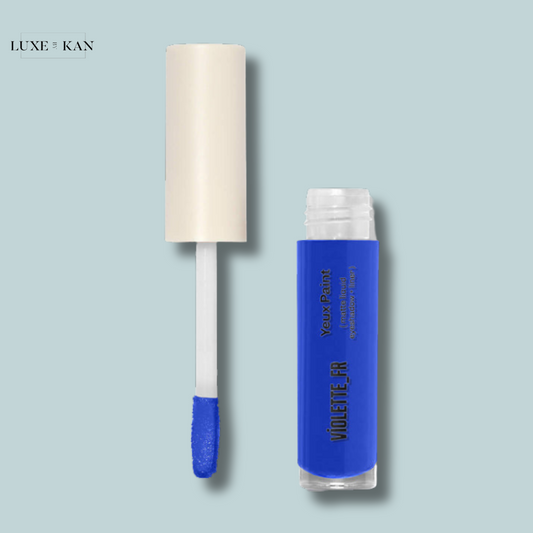 Bright blue eyeshadow in a clear tube with a white applicator, labeled "Yeux Paint" by Violette FR.