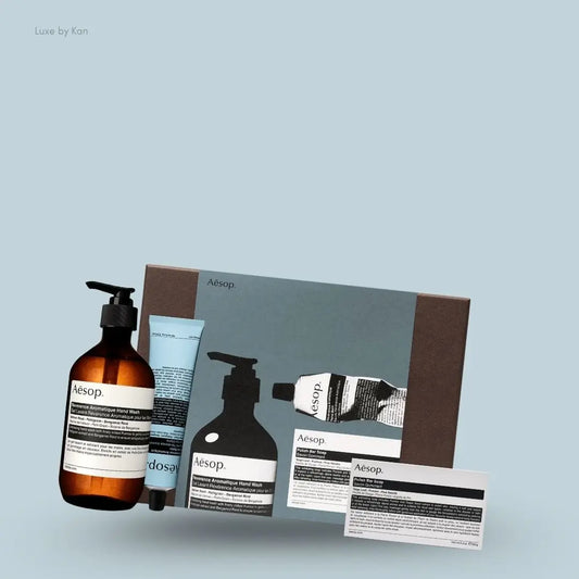 Aesop Reverence Hand Trio set with hand wash, hand balm and bar soap, flat lay on light blue background