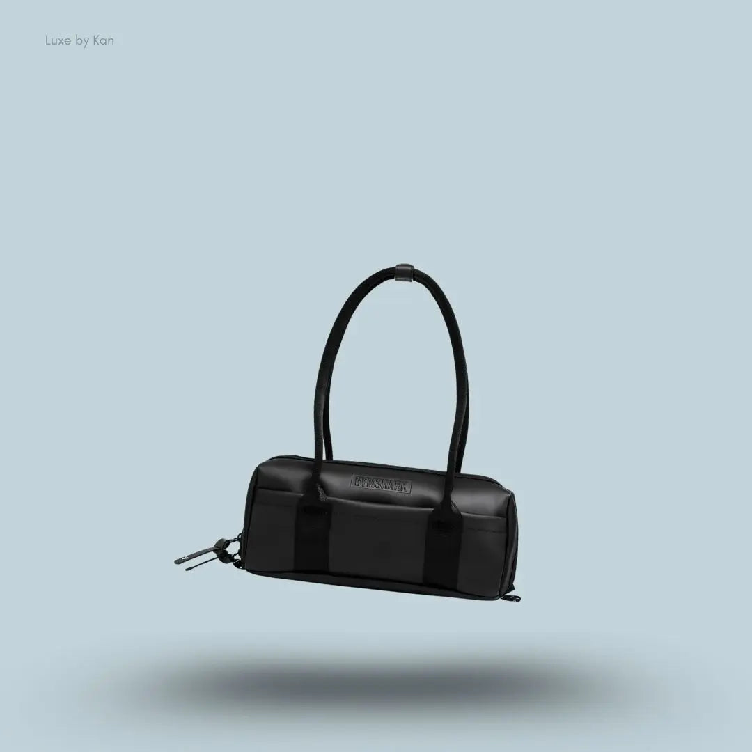 Gymshark Everyday Baguette Bag in black displayed on a blue background with a classic short-handle design