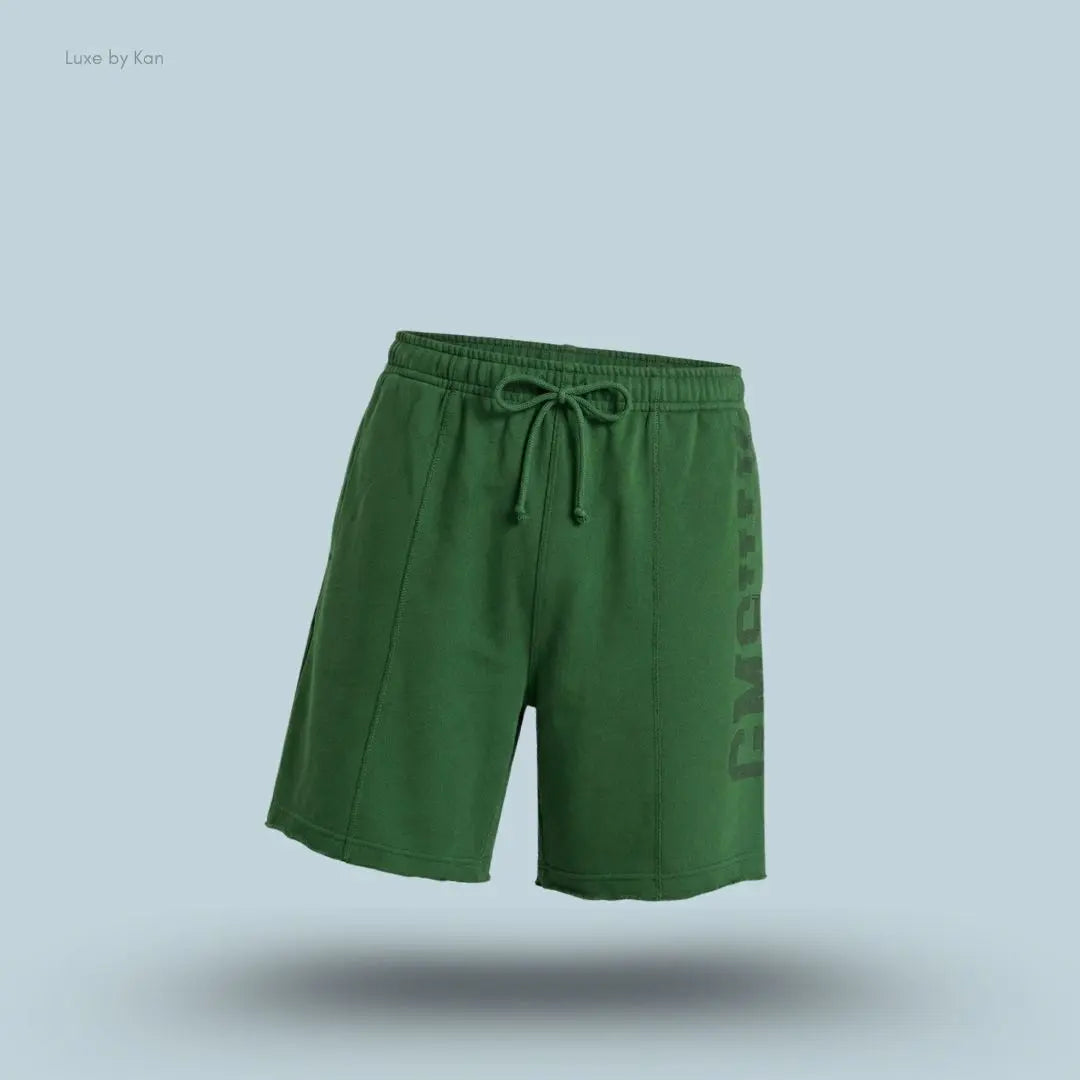 Gymshark Accent Graphic Sweat Shorts in green displayed on a blue background with an oversized fit and raw hem design