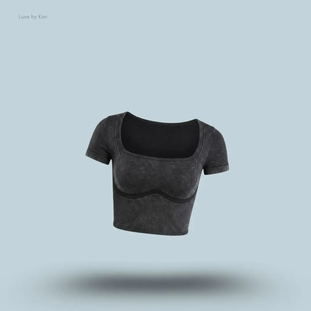 Gymshark x Bratz Crop Top in black displayed on a blue background with a body-fit cropped design