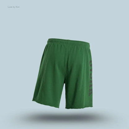 Gymshark Accent Graphic Sweat Shorts in green displayed on a blue background with an oversized fit and raw hem design back view