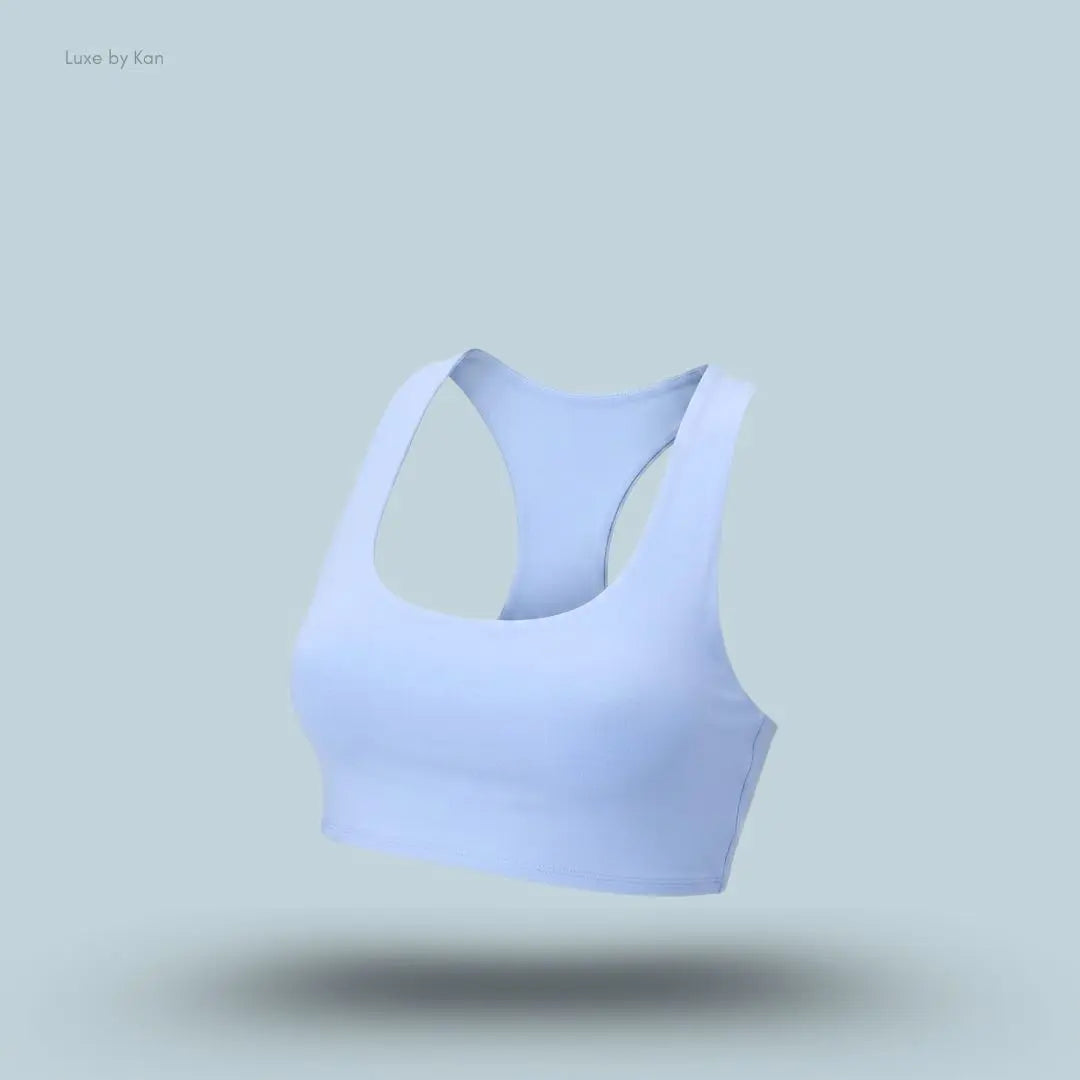Alo Airlift Advantage Racerback Bra in light blue, flat lay on light blue background