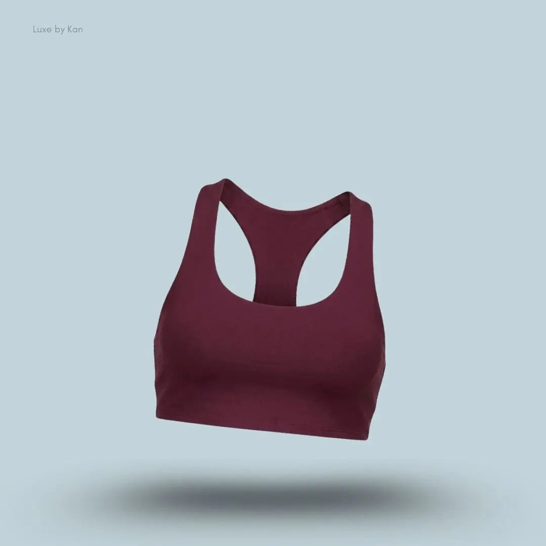 Alo Airlift Advantage Racerback Bra in burgundy, flat lay on light blue background
