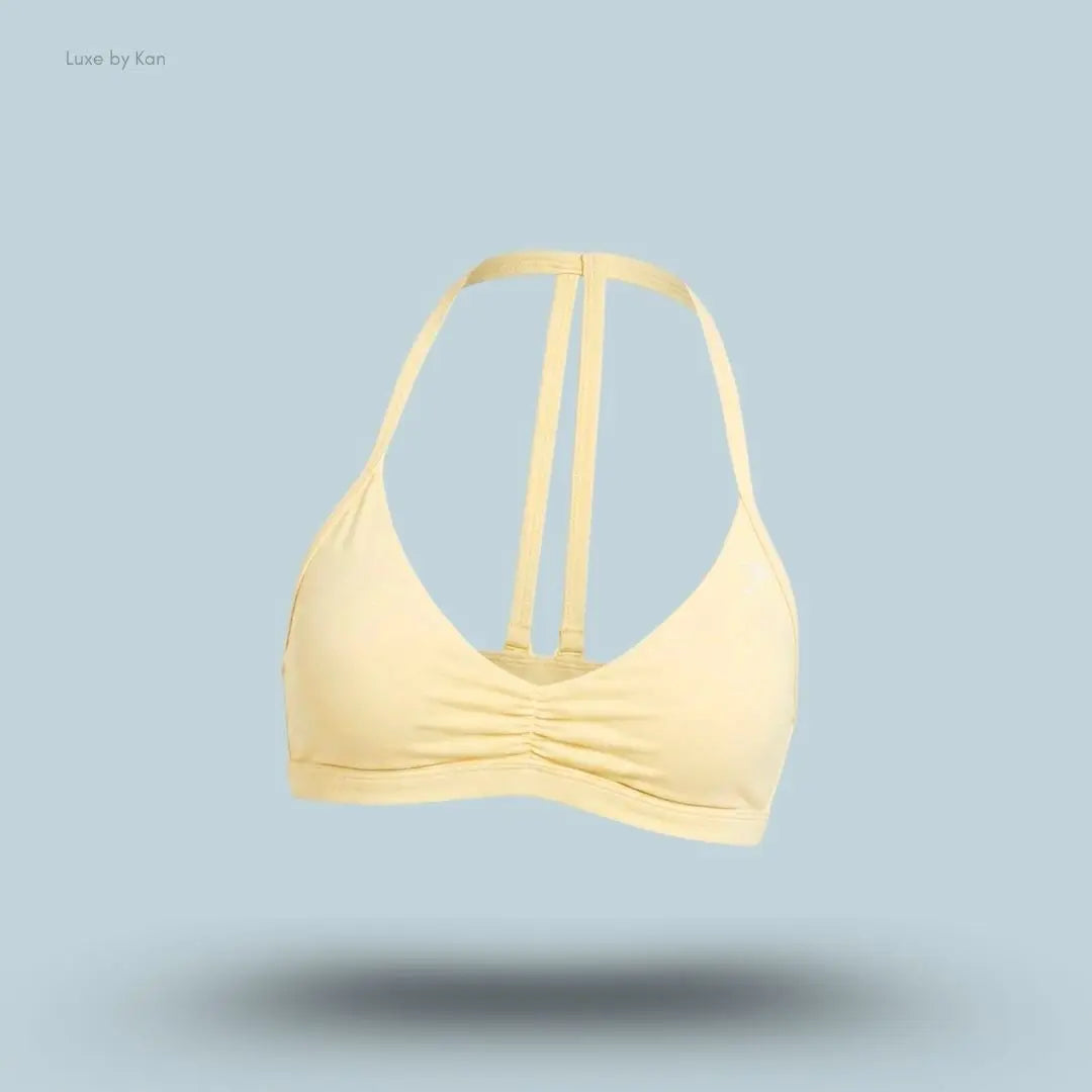 Gymshark Minimal Sports Bra 2.0 in Butter Yellow, flat lay on light blue background