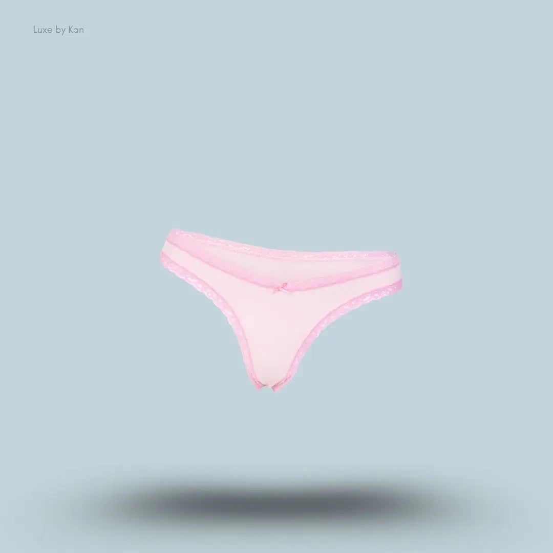 SKIMS Lightweight Cotton Lace Thong in Cherry Blossom, flat lay on light blue background