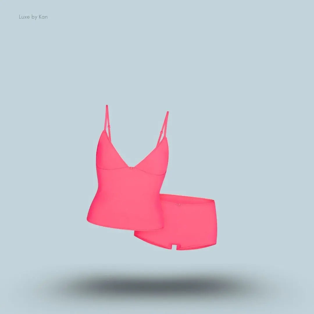 SKIMS Fits Everybody Picot Cami and Boy Short Set in Ultra Pink, flat lay on light blue background