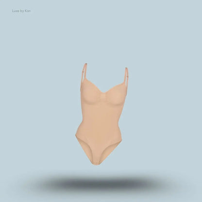 SKIMS Seamless Sculpt Brief Bodysuit in a nude shade, front view with adjustable shoulder straps and seamless sculpting design on blue background