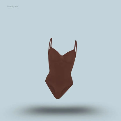 SKIMS Seamless Sculpt Brief Bodysuit in a dark brown shade, front view with adjustable shoulder straps and seamless sculpting design on blue background