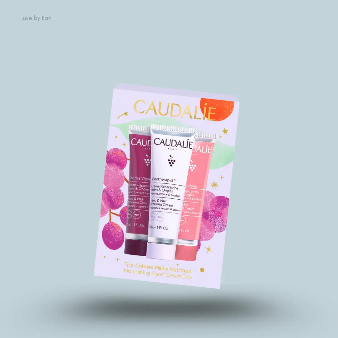 Caudalie Nourishing Hand Cream Trio three hand cream tubes with packaging on blue background