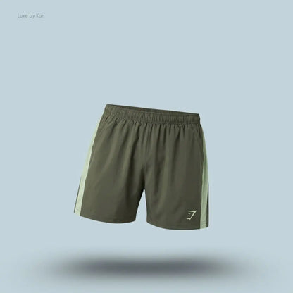 Gymshark Sport 5" Shorts men's slim-fit training shorts in olive green with contrast side panels on a blue background