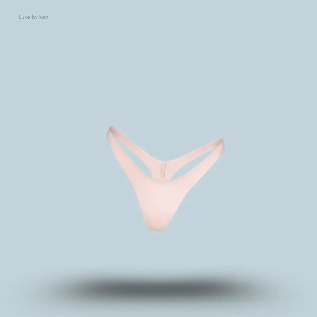 SKIMS Shine Foundations Dipped Thong in Dusky Pink, flat lay on light blue background