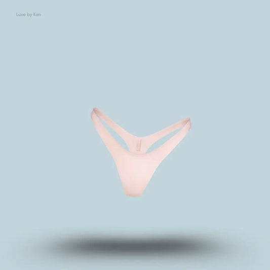 SKIMS Shine Foundations Dipped Thong in Dusky Pink, flat lay on light blue background